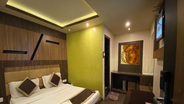 Una habitación de hotel moderna con una cama grande, un escritorio y un televisor.