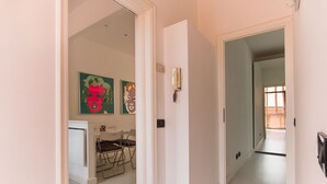 A hallway with a dining area, a phone, and artwork on the wall. - Il Covino (Viareggio)