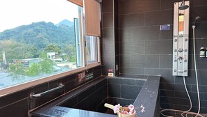 A bathroom with a large window, a shower, and a wooden bucket with flowers. - LiChiuan Hotel Spring Hotel (Tainan)