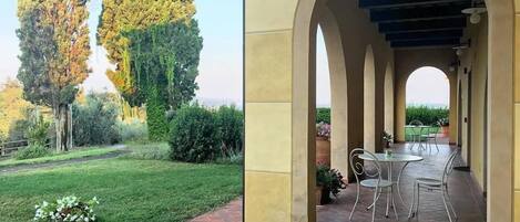 A patio with a brick floor and a covered seating area with metal chairs and a table.