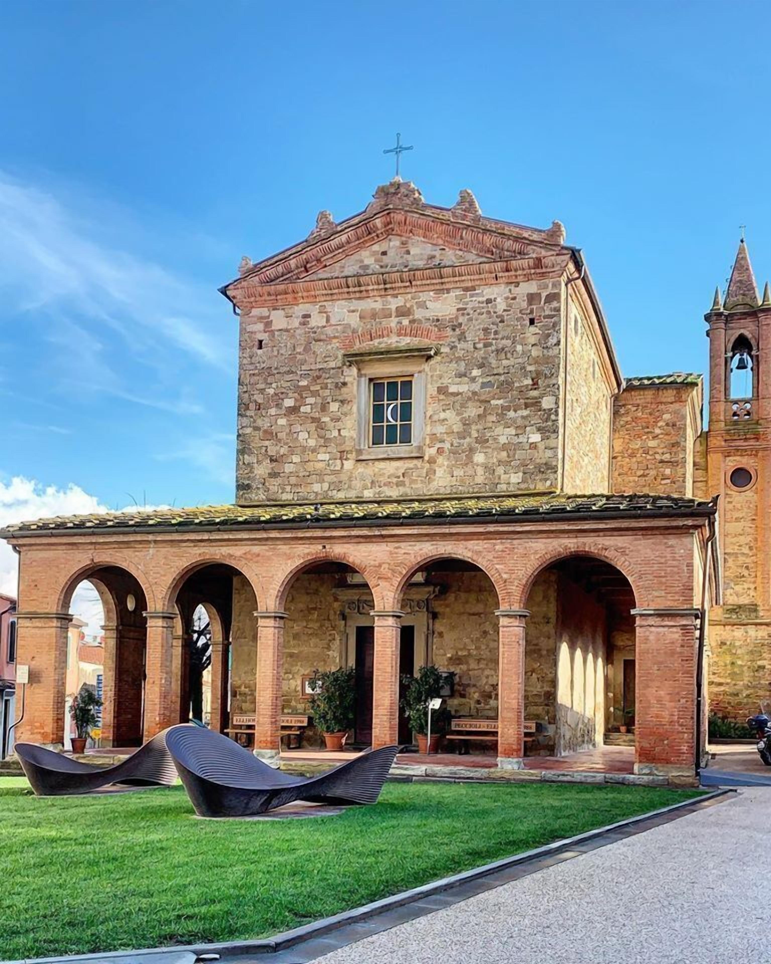 A historic building with a central courtyard, stone arches, and a bell tower.