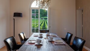 A dining table set with plates, cups, and a chandelier.
