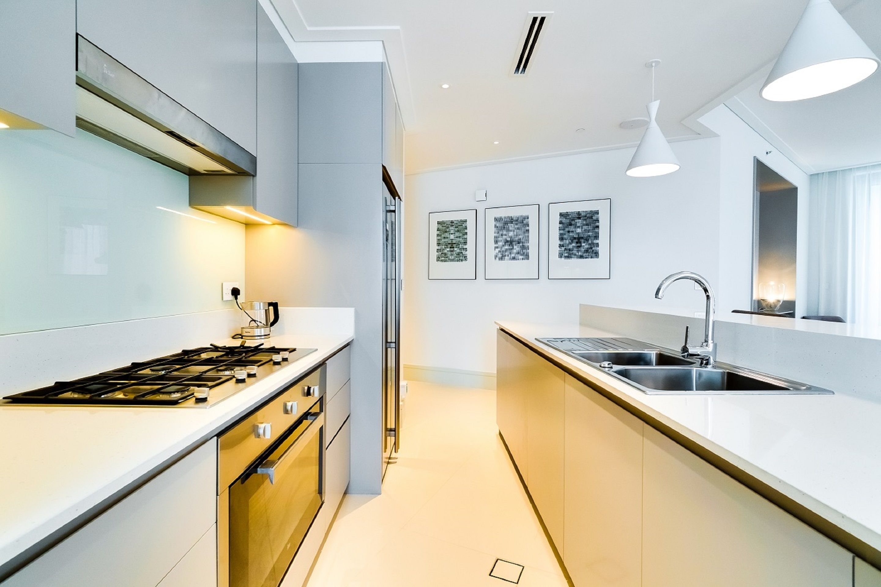 A modern kitchen with a central island, stainless steel appliances, and pendant lighting.