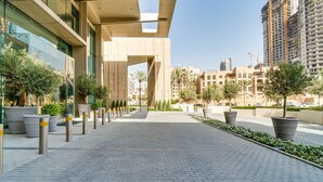 A modern building with a geometric facade, a paved walkway, and potted plants. - Vida Downtown Residences (Dubai)