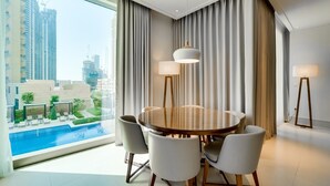 A modern dining area with a round table, six chairs, and two floor lamps. - Vida Downtown Residences (Dubai)