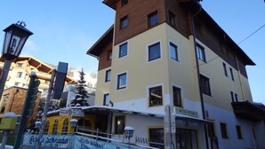 A multi-story hotel with a sign for 'Hotel Peter' and a nearby restaurant named 'Heibe Würstl'. - Hotel Peter (Saalbach-Hinterglemm)