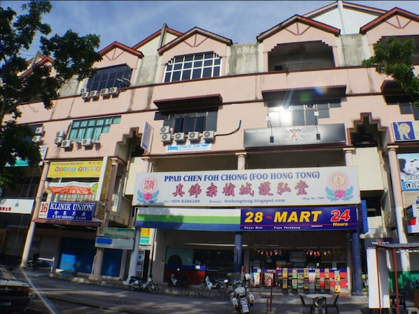 A building with multiple storefronts, including a pharmacy and a convenience store.