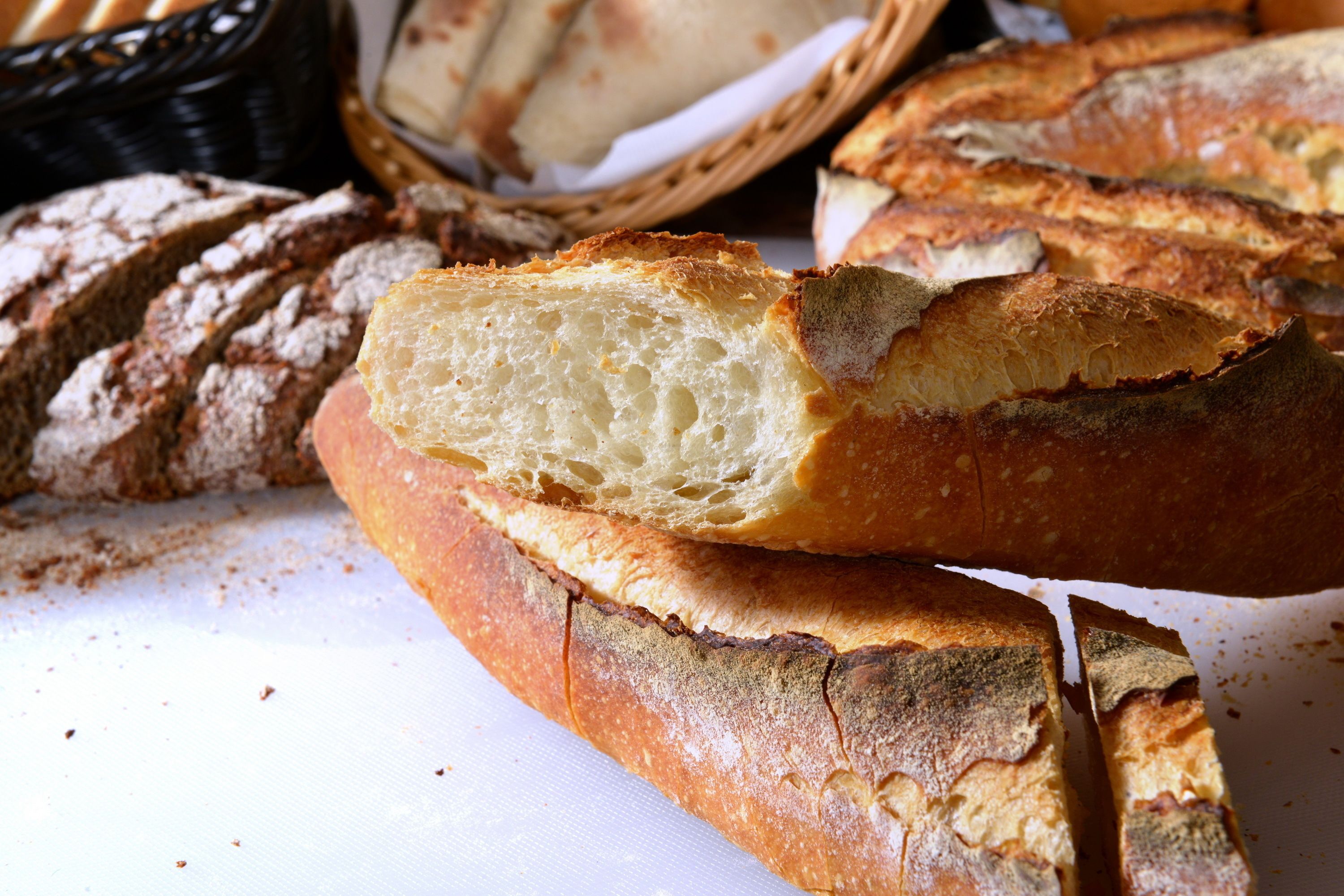 A loaf of bread with a dusting of flour on a white surface.