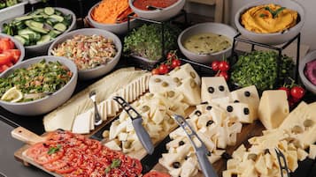 A buffet with various food items including cheese, vegetables, and salads.