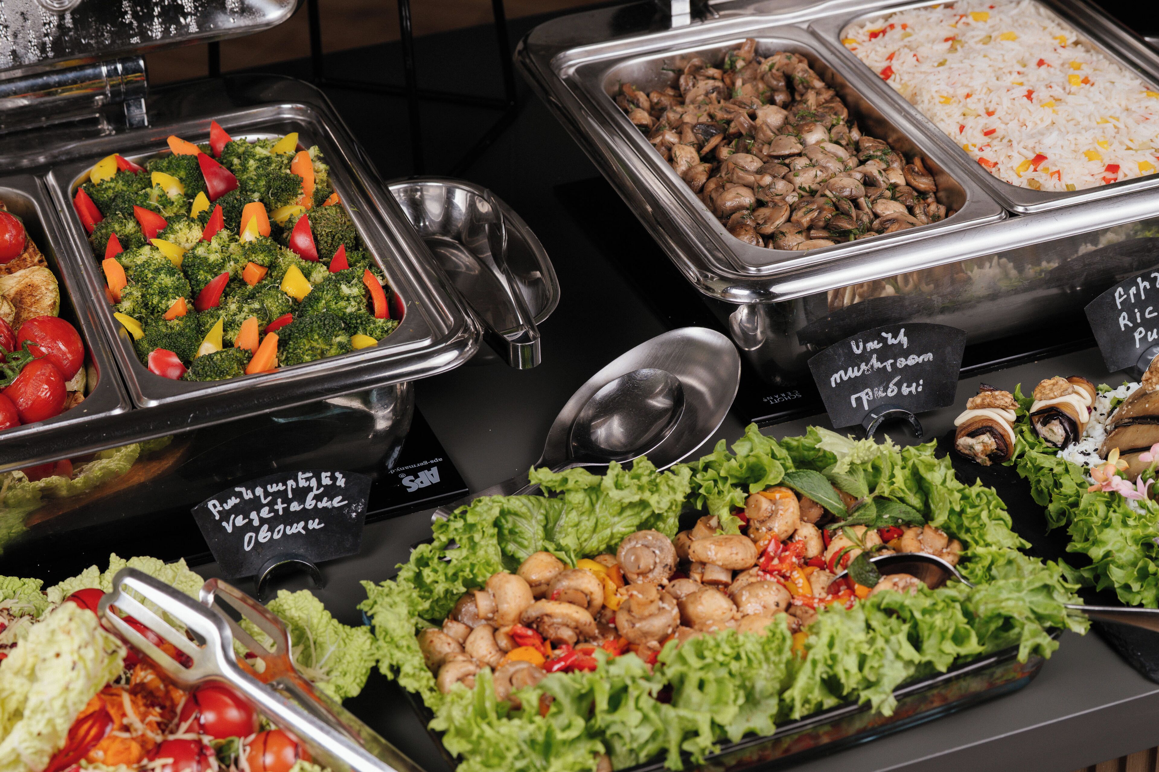 A buffet with various food options including vegetables, rice, and seafood.