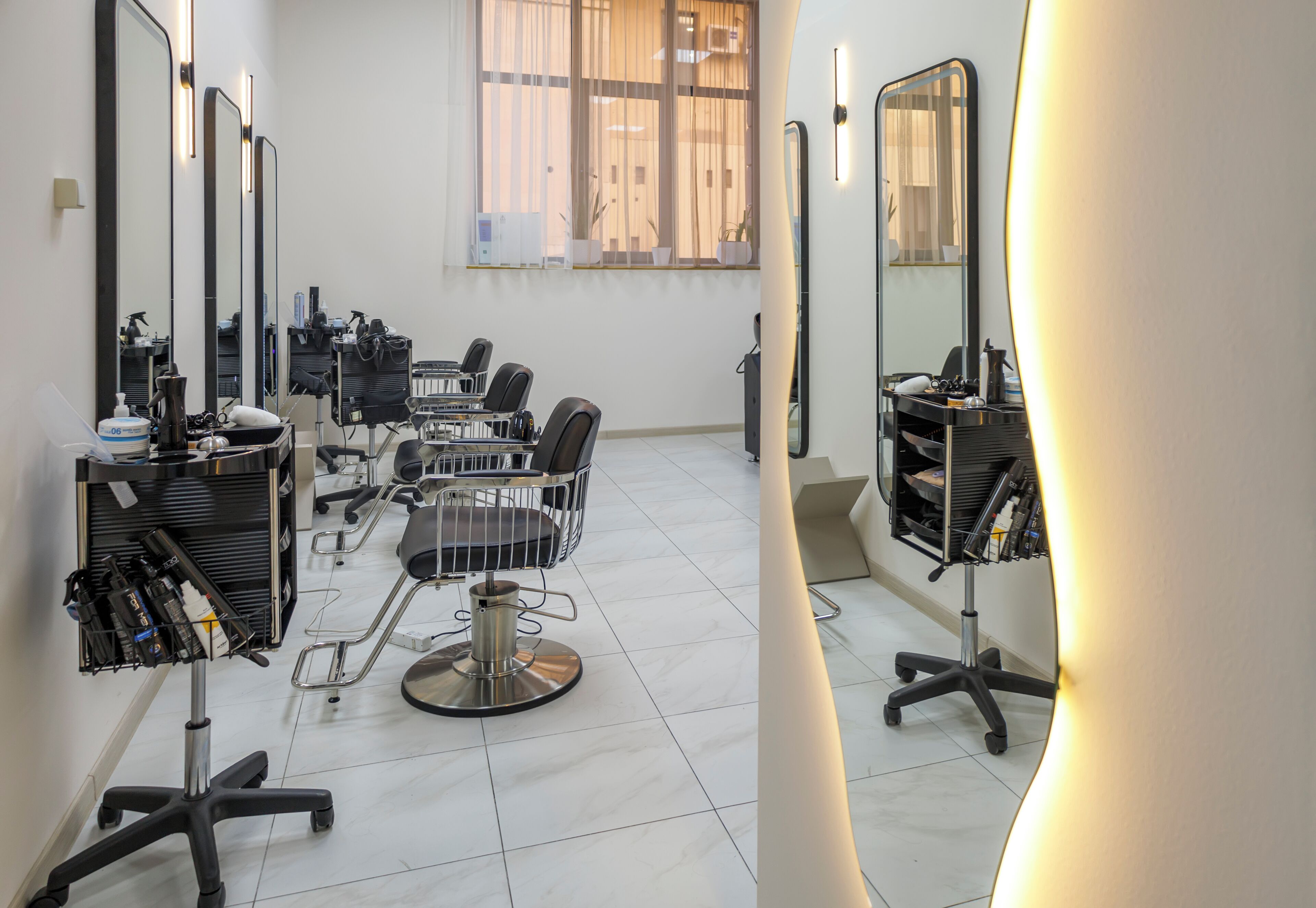 A salon with multiple chairs, mirrors, and a well-lit interior.