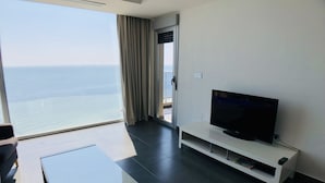 A modern hotel room with a large window offering a sea view, a flat-screen TV on a white stand, and a minimalist design. - La Manga Beach Club - F (San Javier)
