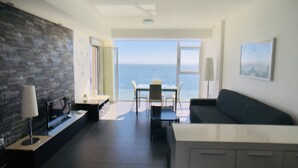 A modern living room with a view of the sea, a dining area, and a kitchen. - La Manga Beach Club - F (San Javier)
