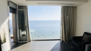 A modern living room with a large sliding glass door leading to a balcony with a sea view. - La Manga Beach Club - F (San Javier)