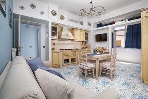 Un espacio habitable compacto con kitchenette, comedor y sofá.