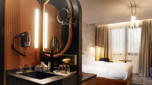 A hotel room with a large mirror, a bed, a desk with a chair, a small table, and a window with curtains. - Mercure Istanbul Bakirkoy (Istanbul)