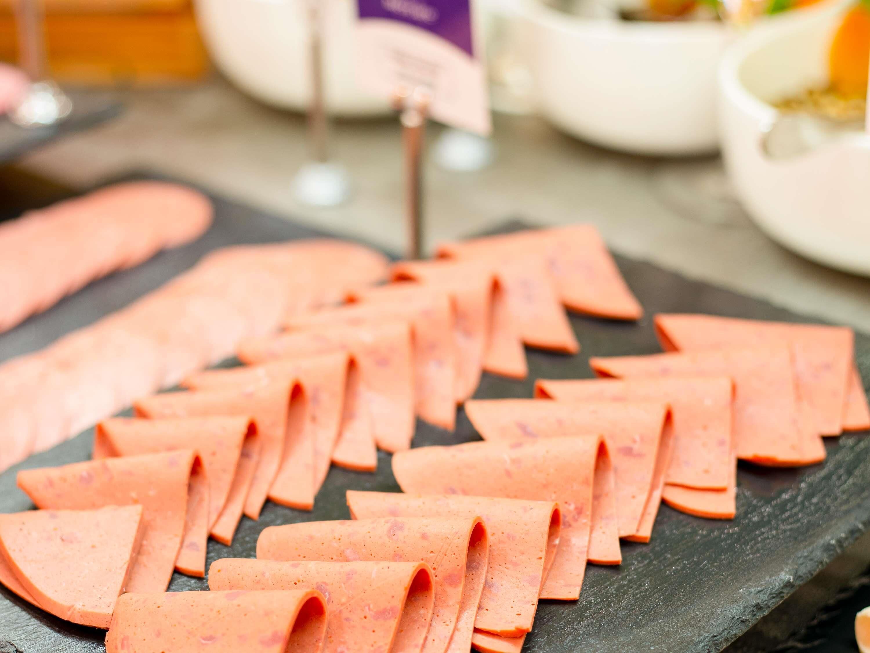 Sliced deli meats on a slate board.