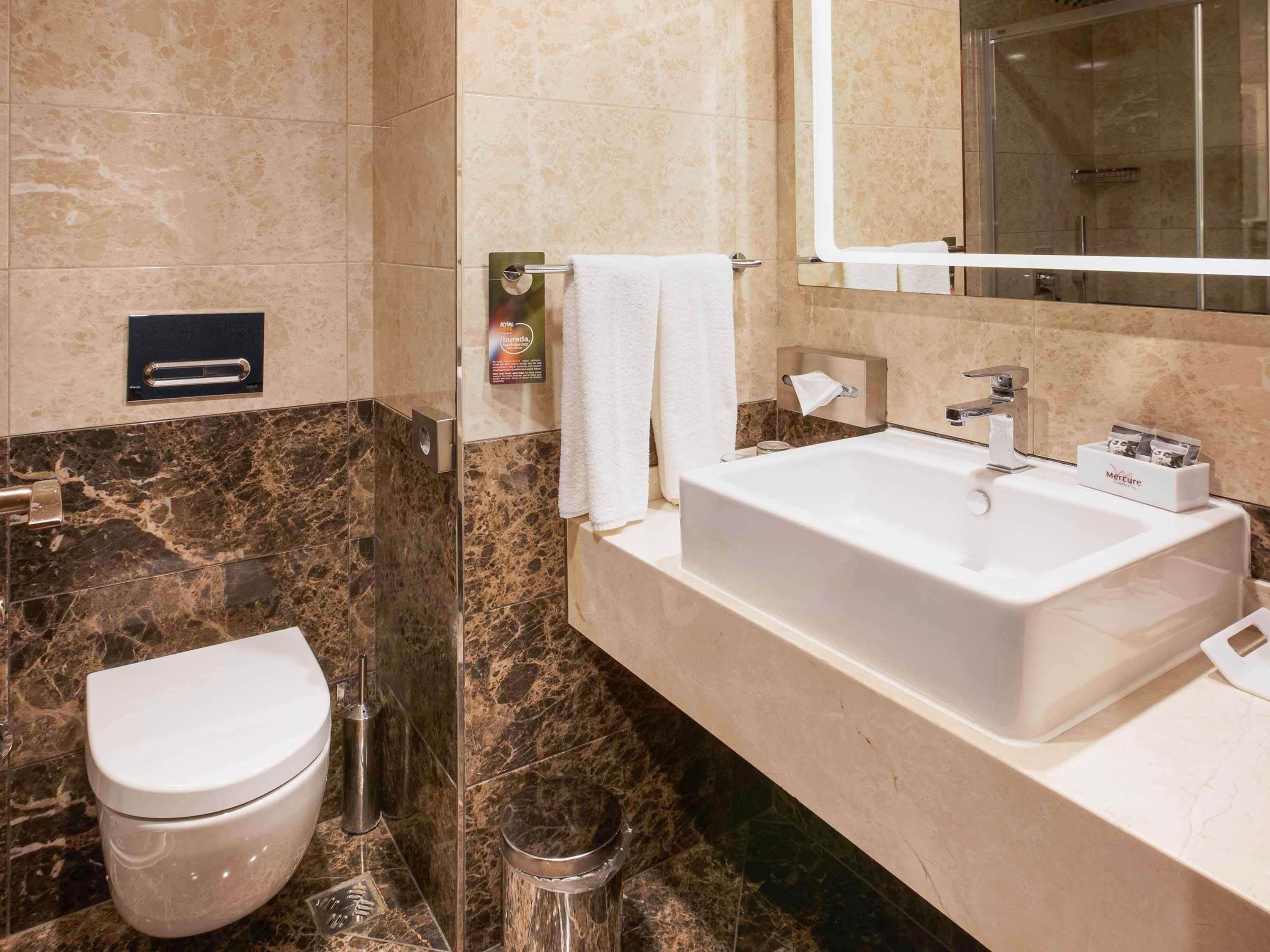 A modern bathroom with a toilet, sink, and shower.