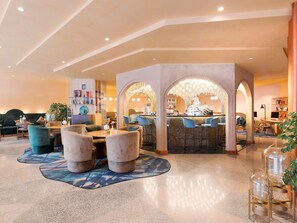 A modern hotel lobby with a bar area, seating, and a bookshelf. - Mercure Istanbul Bakirkoy (Istanbul)