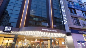 A modern hotel with a glass facade, a prominent entrance, and a sign for the Octo Lounge. - Mercure Istanbul Bakirkoy (Istanbul)