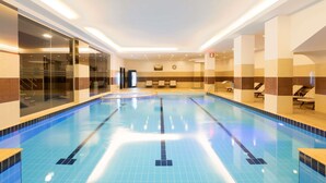 An indoor swimming pool with clear lanes, a reception area, and lounge chairs. - Mercure Istanbul Bakirkoy (Istanbul)