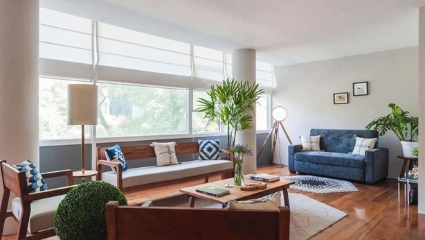 A modern living room with a sofa, coffee table, and chairs, large windows, and a blue couch. - Top Location Polanco by Mr.W (Mexico City)