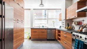 A modern kitchen with wooden cabinets, stainless steel appliances, and a large window providing natural light. - Top Location Polanco by Mr.W (Mexico City)