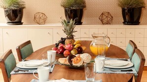 A dining table set with plates, glasses, a pitcher of orange juice, and a fruit bowl. - First Class Apartmet by Mr.W (Mexico City)