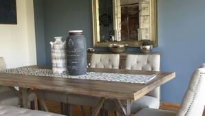 A dining table with a placemat, two decorative vases, and a mirror above it. - Polanco Pearl by Mr.W (Mexico City)
