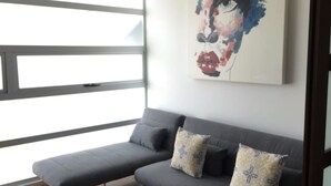 A modern living room with a grey sofa, two patterned cushions, and a large abstract painting on the wall. - Polanco Pearl by Mr.W (Mexico City)