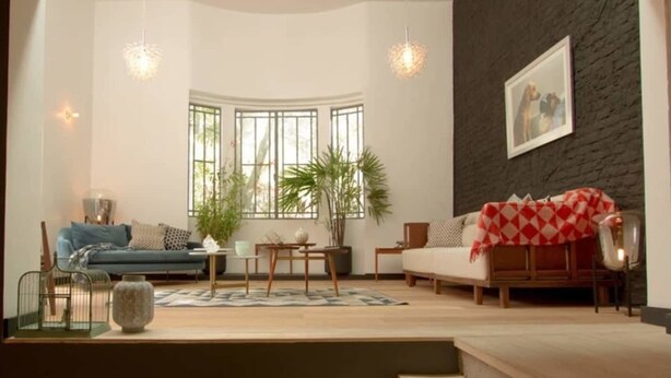 A modern living room with a blue sofa, a red and white checkered throw, a wooden coffee table, and a large window with plants. - Unique Roma Town House by Mr.W (Mexico City)