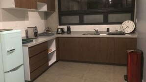 A compact kitchen with a refrigerator, stove, sink, and a clock on the wall. - Unique Roma Town House by Mr.W (Mexico City)
