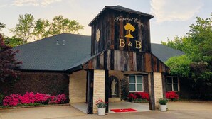 A wooden building with a sign reading "Krepsol Estate B&B" and a tree logo. - Kiepersol Bed and Breakfast (Tyler)