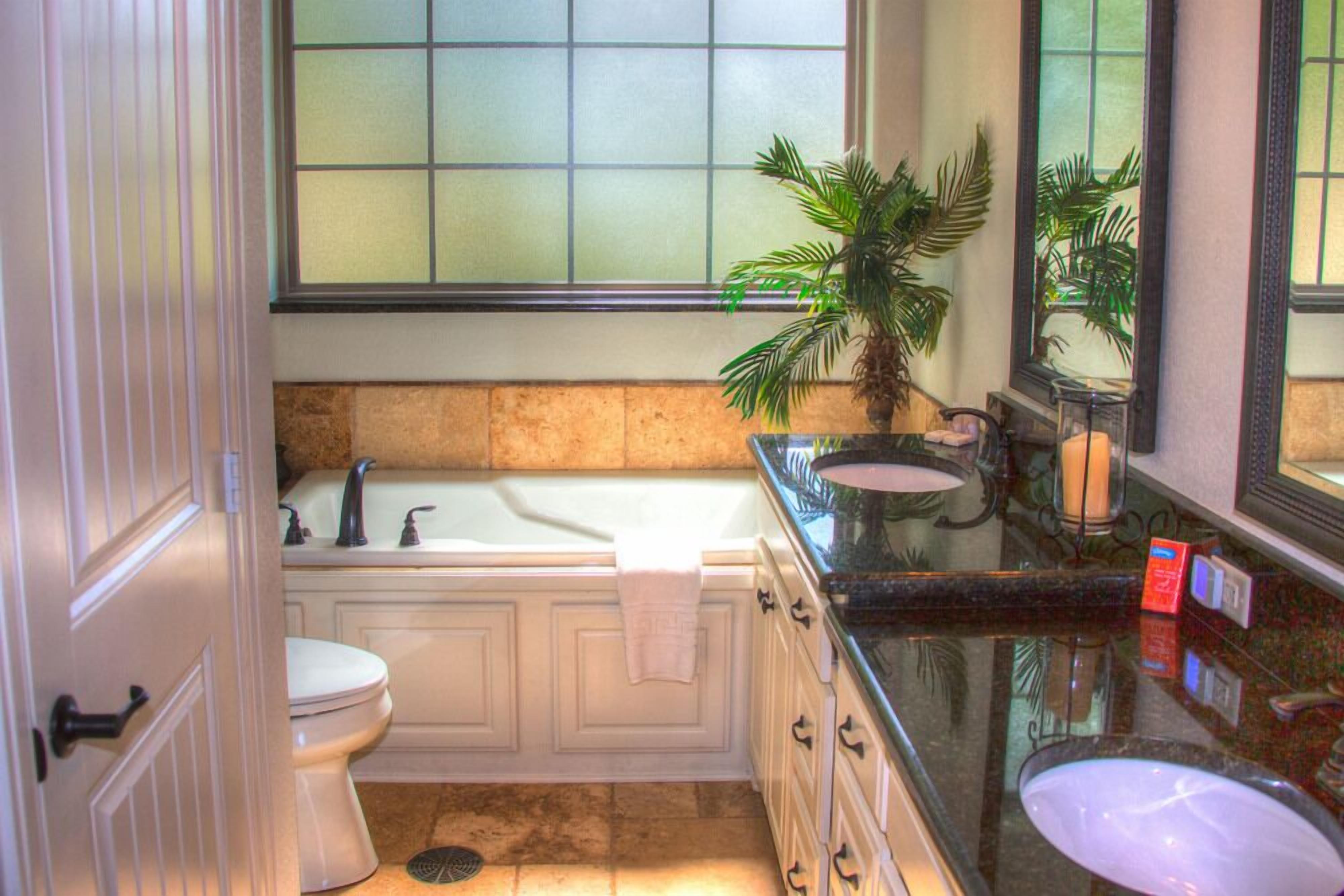 A bathroom with a white toilet, a bathtub, a sink, and a mirror.