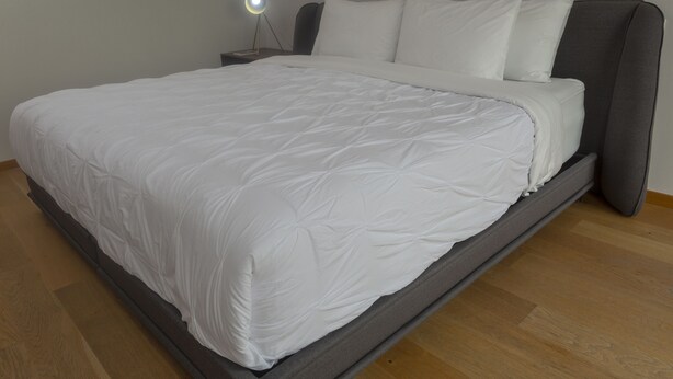 A neatly made bed with white bedding, a bedside lamp, and a wooden floor. - Modern PH in Heart of la Roma by Mr.W (Mexico City)