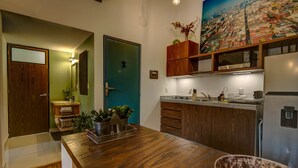 A modern kitchen with wooden cabinets, a stainless steel refrigerator, and a large cityscape painting above the counter. - Zen Modern by Mr.W (Mexico City)