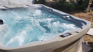 A hot tub with a control panel, surrounded by a garden. - OBX Beach Xanadu -  .7 miles to the beach plus HOTTUB! 🏖🏄‍♀️👙🩳🩱🩴🕶🏌‍♂️🚲  (Kill Devil Hills)