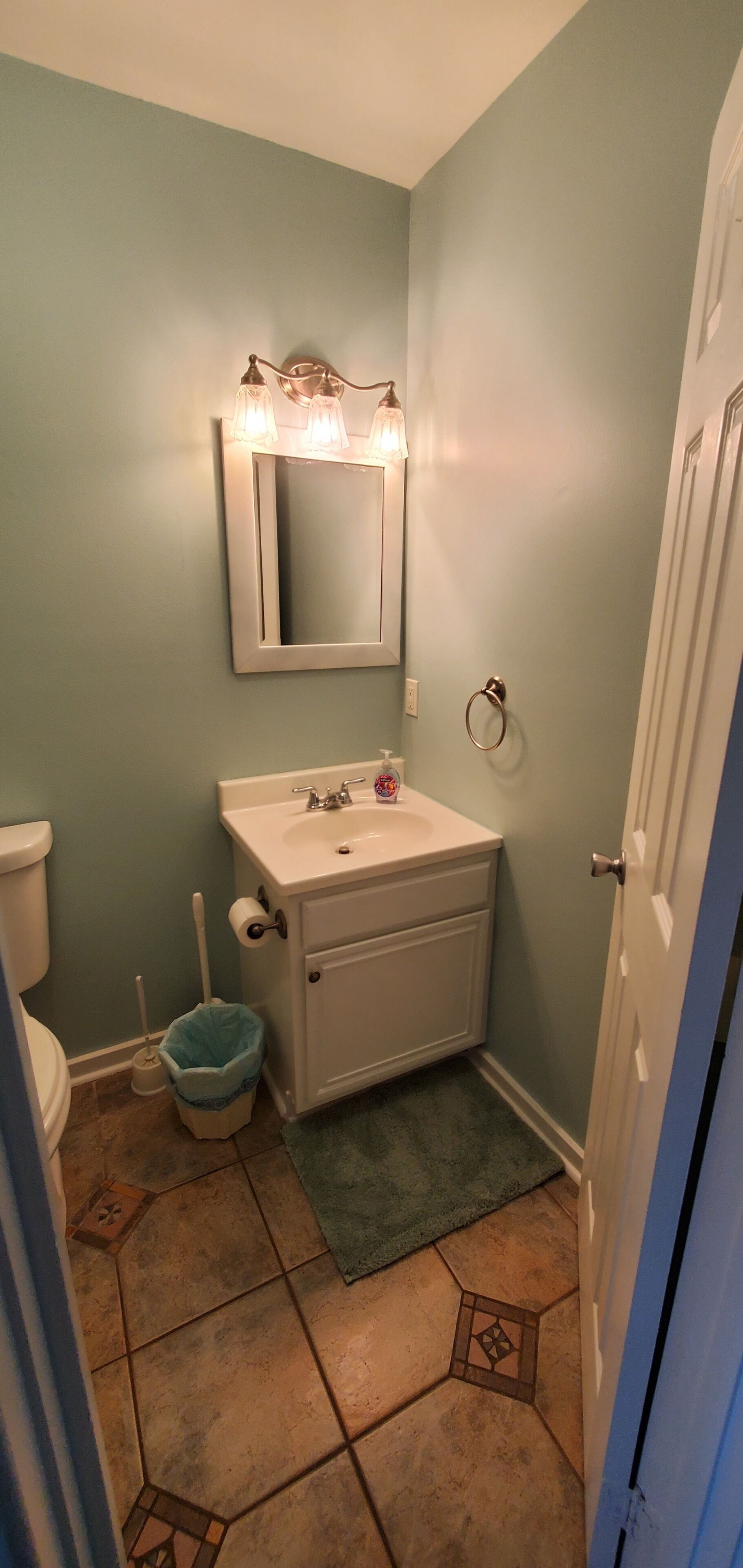 A small bathroom with a sink, mirror, and toilet.