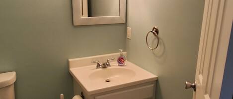 A small bathroom with a sink, mirror, and toilet.