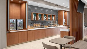 Una cocina moderna con armarios de madera, un refrigerador integrado y una encimera con diversos alimentos.