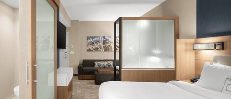 Ein Hotelzimmer mit Bett, Sofa, Schreibtisch, Kleiderschrank und Bad.