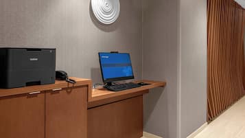 A reception desk with a Brother printer, a Brother laptop, and a phone.