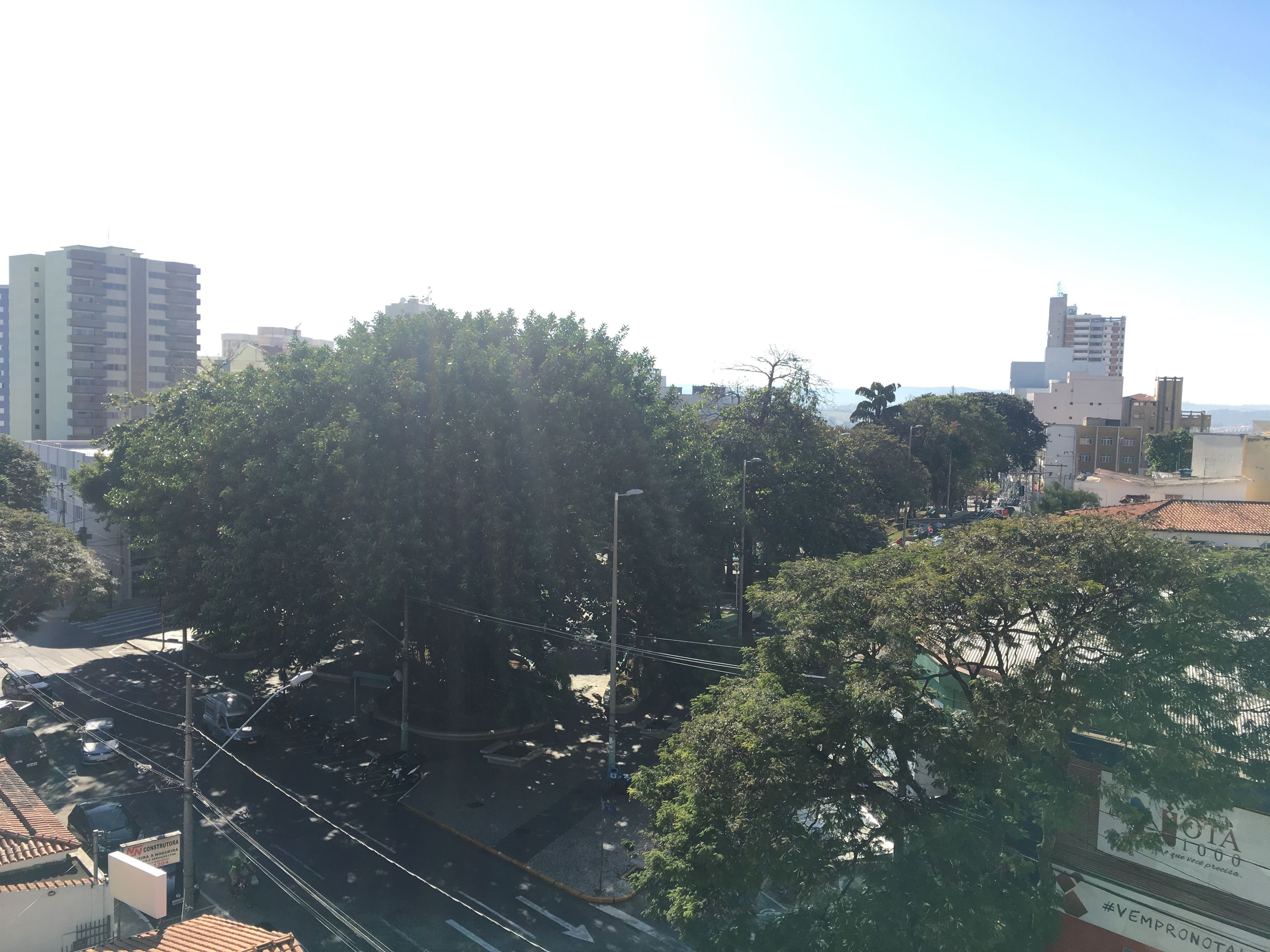 A view of a cityscape with buildings, trees, and a construction site.