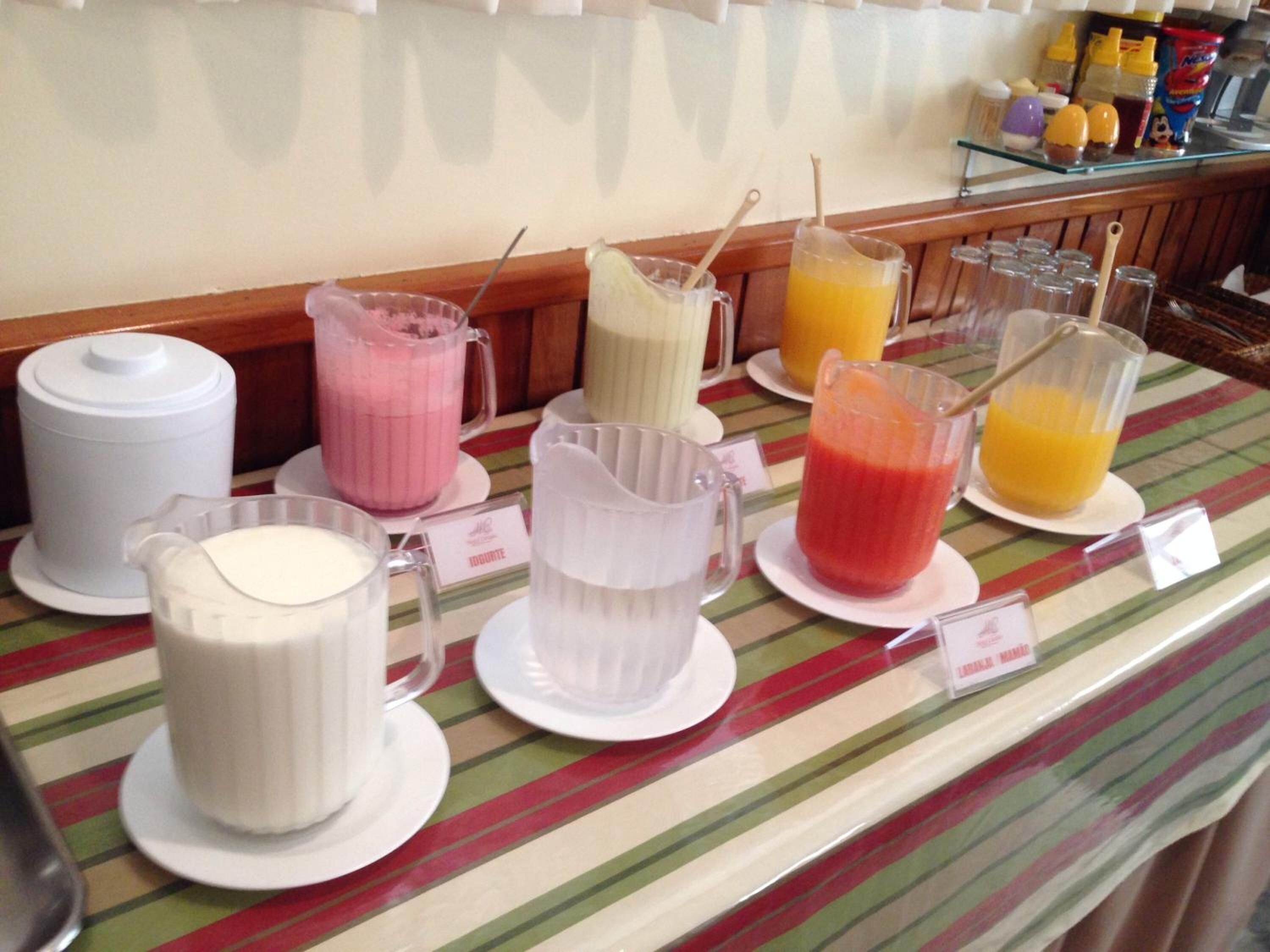 Mostrador de buffet con diversas bebidas y dispensador de leche.