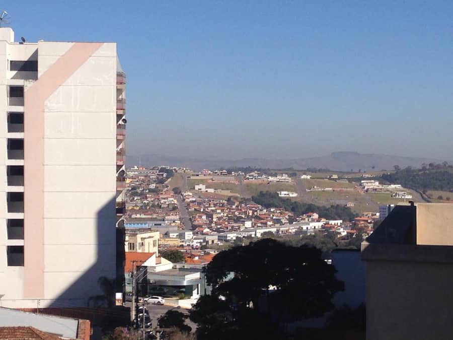 Un edificio de gran altura con vistas despejadas a una localidad, que presenta una combinación de edificios residenciales y comerciales.