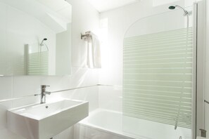 Een bad/douchecombinatie, een haardroger, een bidet, handdoeken