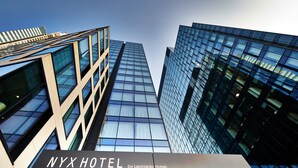 A NYX Hotel by Leonardo Hotels with a modern glass facade and a prominent entrance sign. - NYX Hotel Warsaw by Leonardo Hotels (Warsaw)