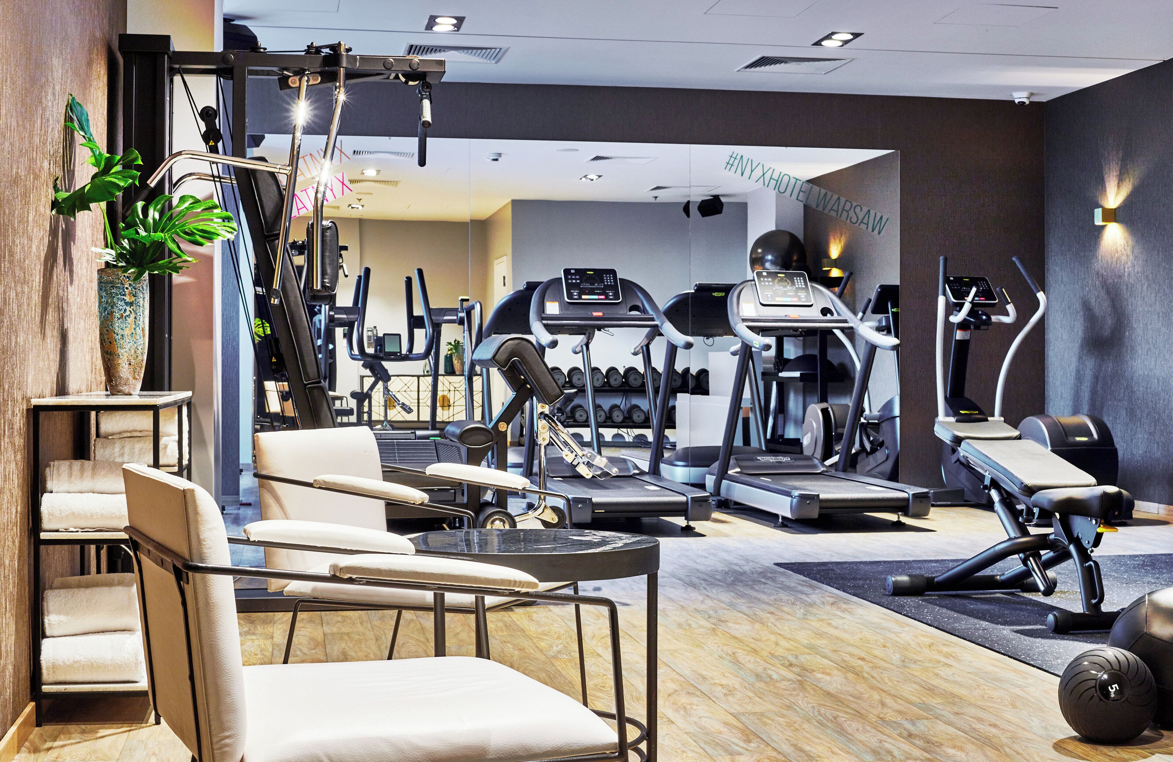 A modern gym with various exercise equipment, including treadmills and weight machines.