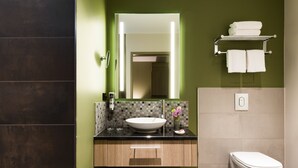 A modern bathroom with a large mirror, a vessel sink, and a toilet. - Leonardo Hotel Offenbach Frankfurt (Offenbach am Main)
