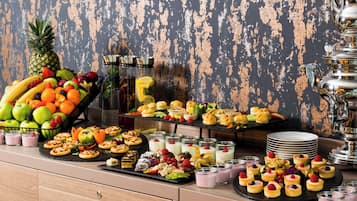 Un tavolo da buffet con diversi cibi e un elegante teiera d'argento.